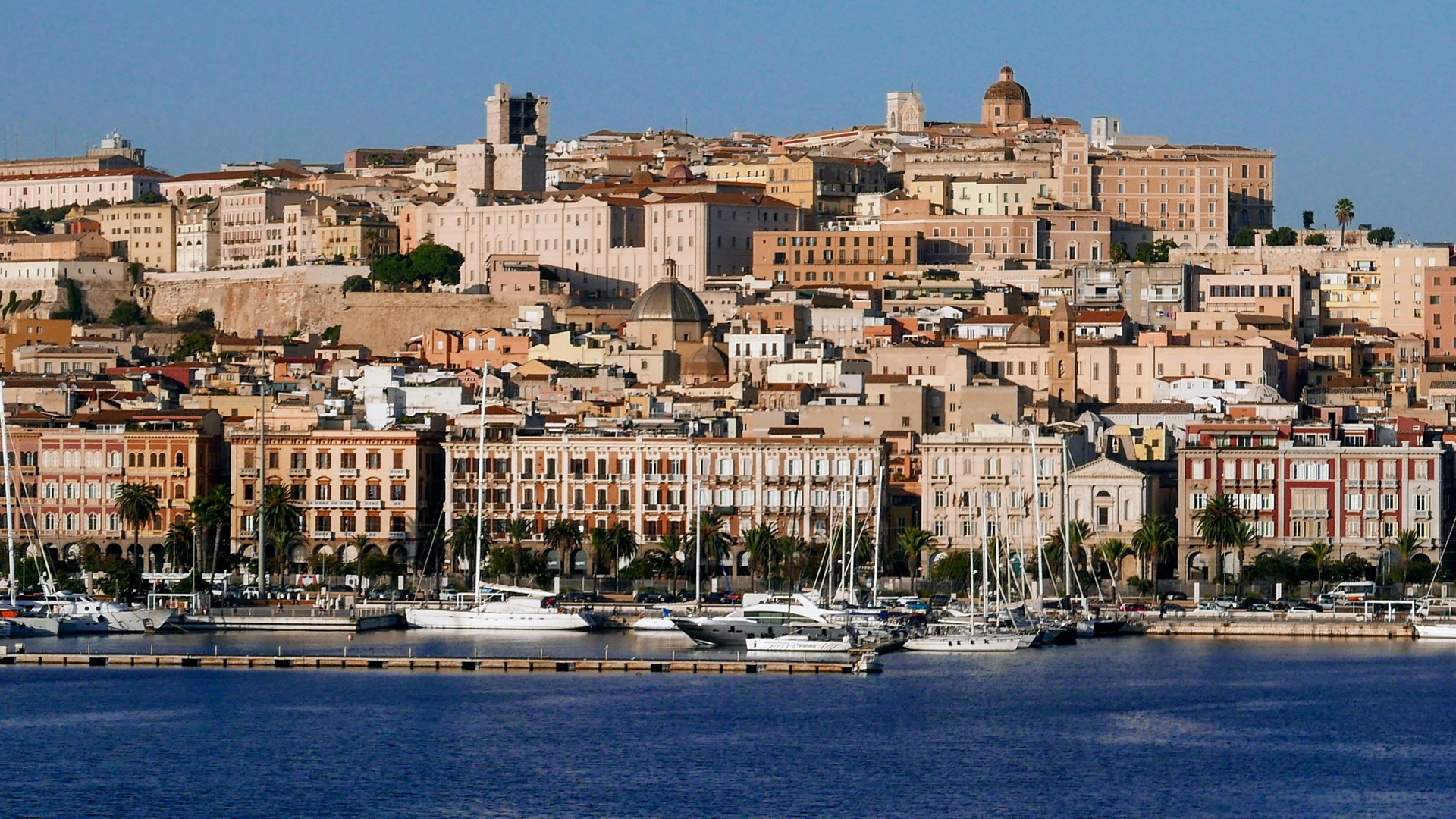 Via Roma seafront promenade in Cagliari with historic buildings and the harbour